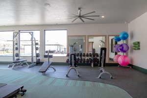 Exercise room with ceiling fan, a textured ceiling, and a wealth of natural light