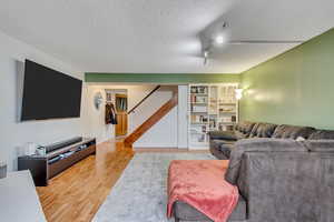 Living room with hardwood / wood-style floors, built in features, and a textured ceiling