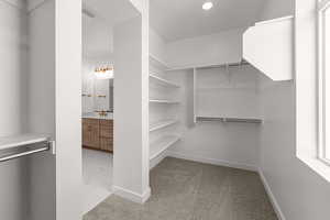 Spacious closet featuring marble finish floor and a sink