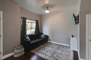 Sitting room featuring dark wood-type flooring