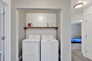 Laundry room with washing machine and dryer and carpet floors