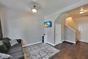 Living room with dark wood-type flooring