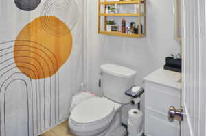 Bathroom with hardwood / wood-style floors, toilet, and walk in shower