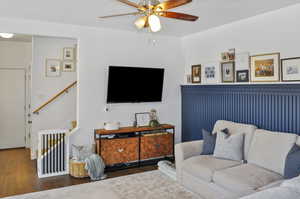 Living room with ceiling fan and dark hardwood / wood-style floors