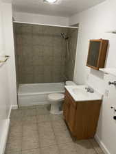 Full bathroom with tile patterned floors, vanity, toilet, and tiled shower / bath