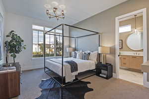 Carpeted bedroom with an inviting chandelier, ensuite bath, multiple windows, and sink