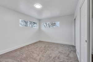Unfurnished bedroom featuring light colored carpet