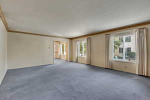 Empty room featuring carpet flooring and ornamental molding