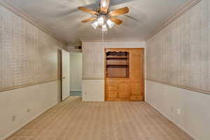 Unfurnished room with light carpet, ceiling fan, and ornamental molding