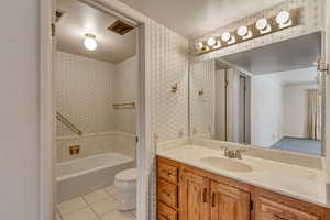 Full bathroom featuring tile patterned floors, vanity, shower / bath combination, and toilet