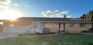 Single story home featuring a garage and a front lawn