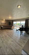 Living room with a textured ceiling and hardwood / wood-style flooring