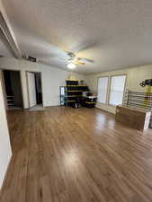 Office space with ceiling fan, a textured ceiling, and hardwood / wood-style flooring