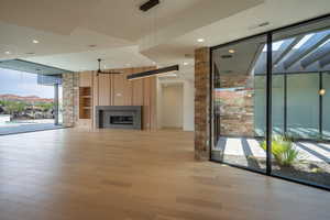 Unfurnished living room with floor to ceiling windows, ceiling fan, a mountain view, and light hardwood / wood-style floors