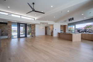 Kitchen with light stone counters, plenty of natural light, a large island, and light wood-type flooring