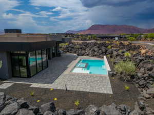 View of swimming pool featuring a mountain view, a patio, and an in ground hot tub