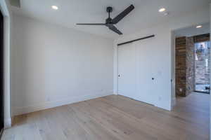 Unfurnished bedroom with ceiling fan, a closet, and light hardwood / wood-style flooring