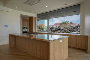 Kitchen featuring light stone countertops, a center island, sink, and stainless steel gas cooktop