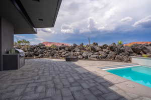 View of pool with a mountain view, area for grilling, a patio area, and exterior kitchen