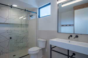 Bathroom featuring toilet, tile walls, and walk in shower