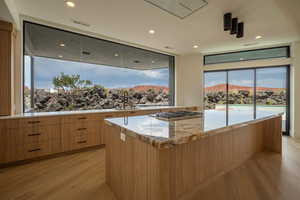 Kitchen featuring a large island, sink, stainless steel gas cooktop, a mountain view, and light hardwood / wood-style floors