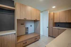 Clothes washing area with washer hookup, cabinets, and hookup for an electric dryer