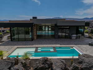 View of pool featuring a mountain view, a patio, and grilling area