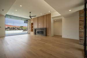 Unfurnished living room with ceiling fan and light hardwood / wood-style floors