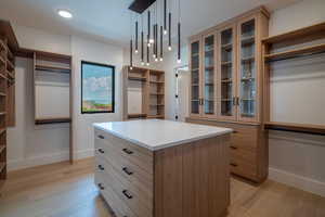 Walk in closet with light wood-type flooring