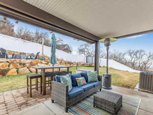 View of patio with an outdoor hangout area and central AC unit