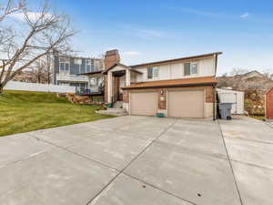 Raised ranch with a front lawn and a garage