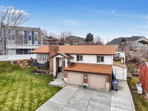 View of front of property featuring a front yard and a garage