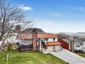 View of front of home with a front yard, a mountain view, and a garage