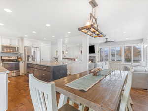 Dining area with ceiling fan and dark wood-type flooring