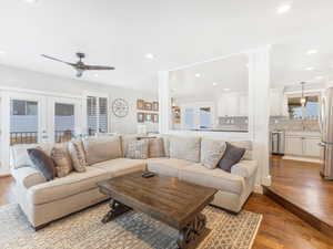 Living room with ceiling fan, ornate columns, light hardwood / wood-style flooring, and french doors