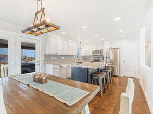 Kitchen featuring white cabinets, pendant lighting, stainless steel appliances, and a kitchen island