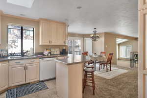 Kitchen featuring dishwasher, breakfast bar & tons of natural light