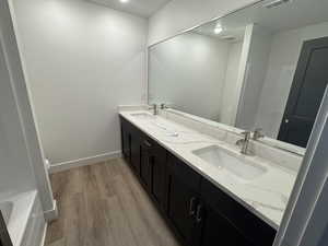 Bathroom with hardwood / wood-style floors, vanity, and toilet