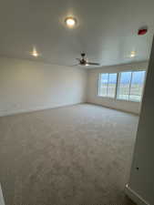 Empty room with ceiling fan and carpet floors