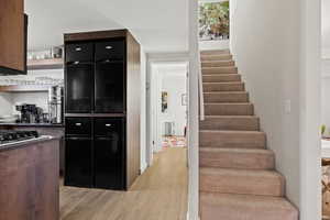 Kitchen with light hardwood / wood-style floors and radiator heating unit