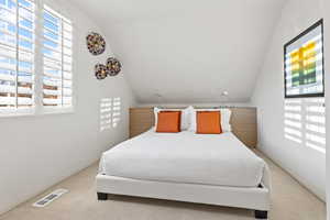 Carpeted bedroom featuring lofted ceiling