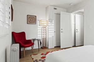 Bedroom featuring light hardwood / wood-style floors and radiator