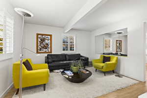 Living room featuring beam ceiling and wood-type flooring