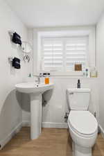 Bathroom featuring wood-type flooring and toilet