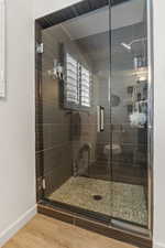 Bathroom featuring hardwood / wood-style flooring, toilet, and walk in shower