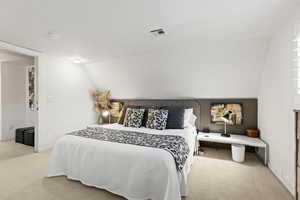 Carpeted bedroom with lofted ceiling