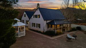 Back house at dusk with a porch