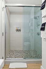 Bathroom featuring hardwood / wood-style floors and walk in shower