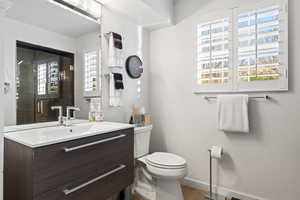 Bathroom with hardwood / wood-style floors, vanity, and toilet