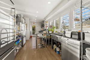 Kitchen with dishwasher, wood-type flooring, and sink